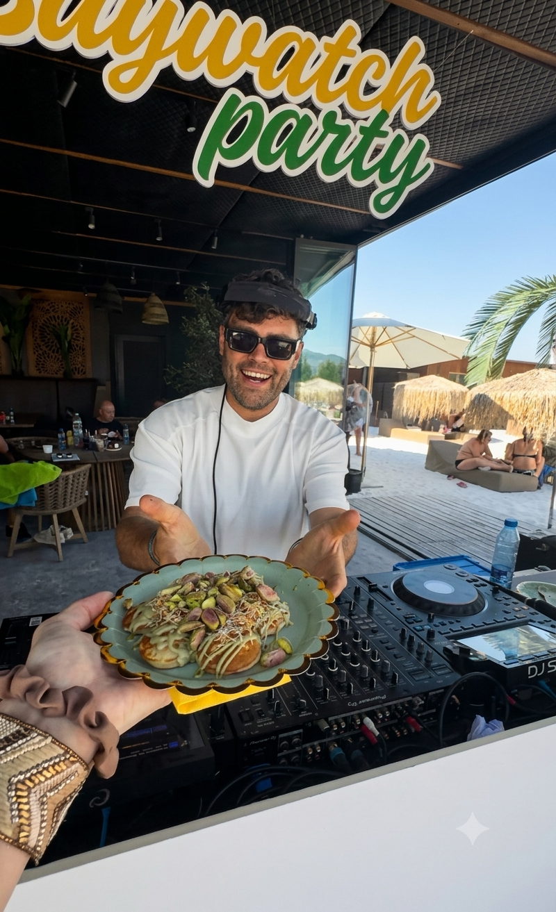 Гост с чиния мини палачинки с шам фъстък до DJ пулта